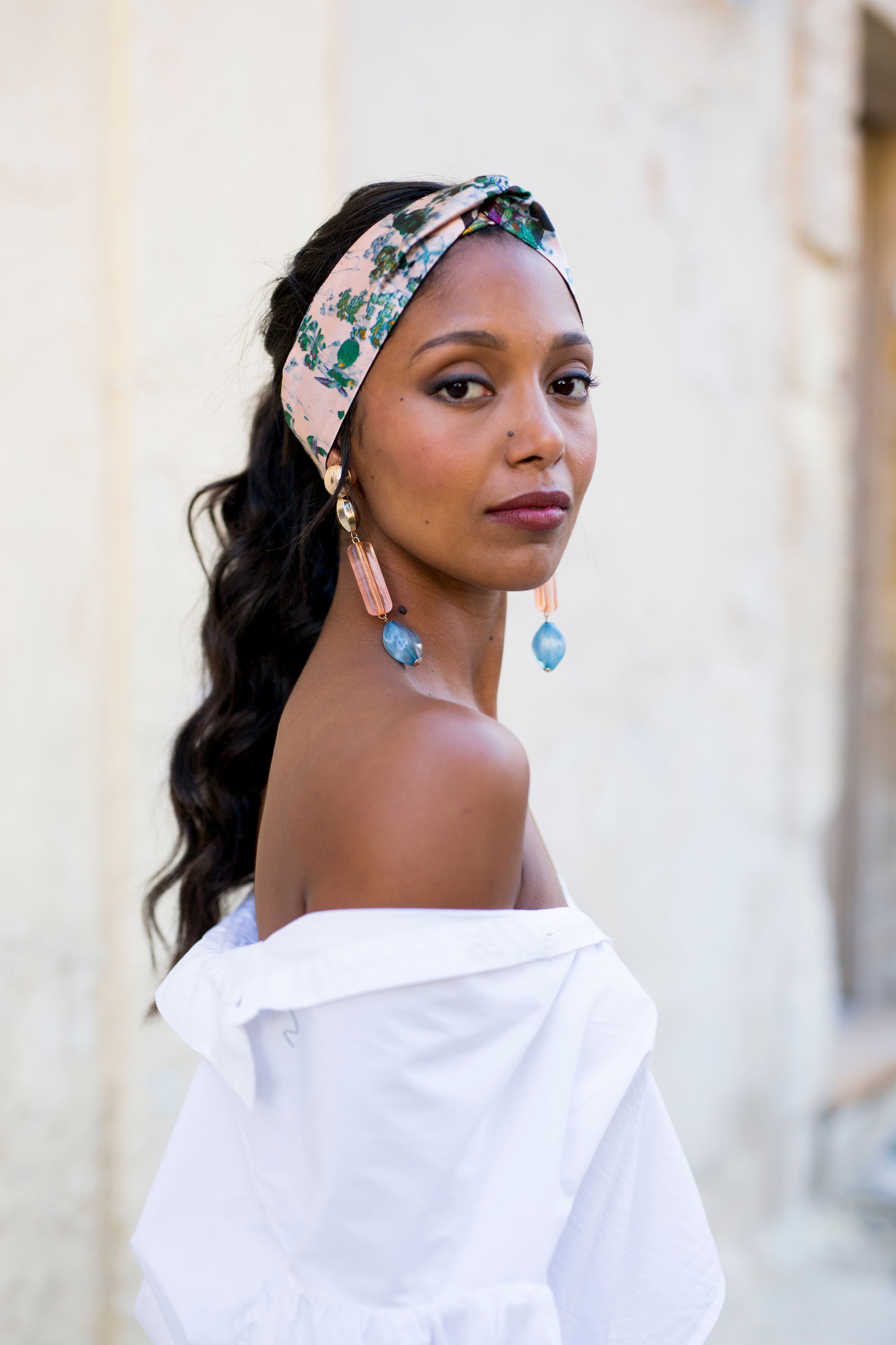 Model in a white off shoulder shirt with a floral headband