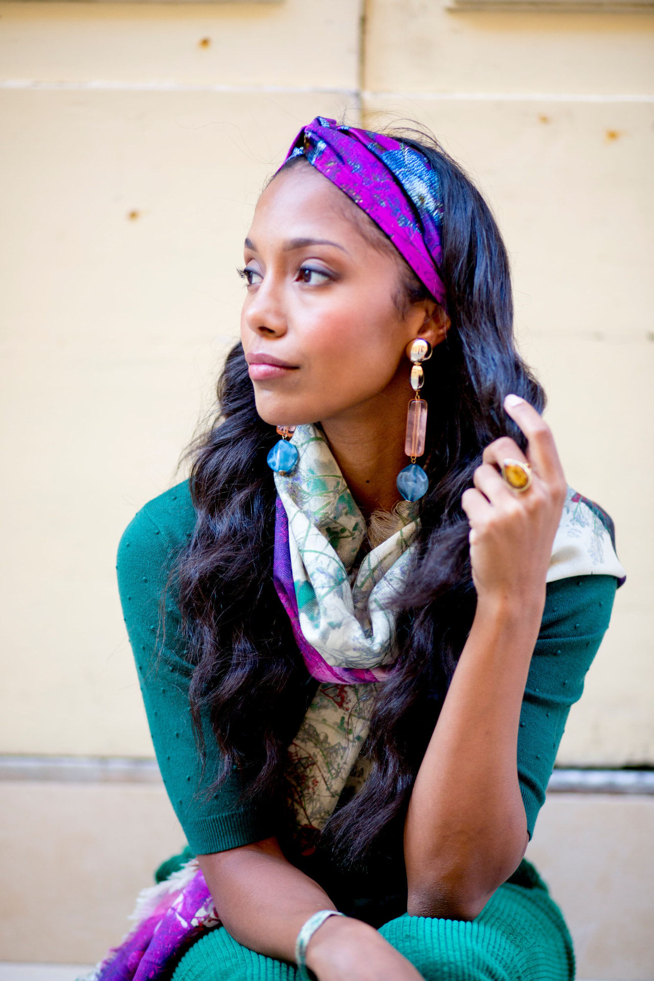 Model in teal knit with a purple silk headscarf