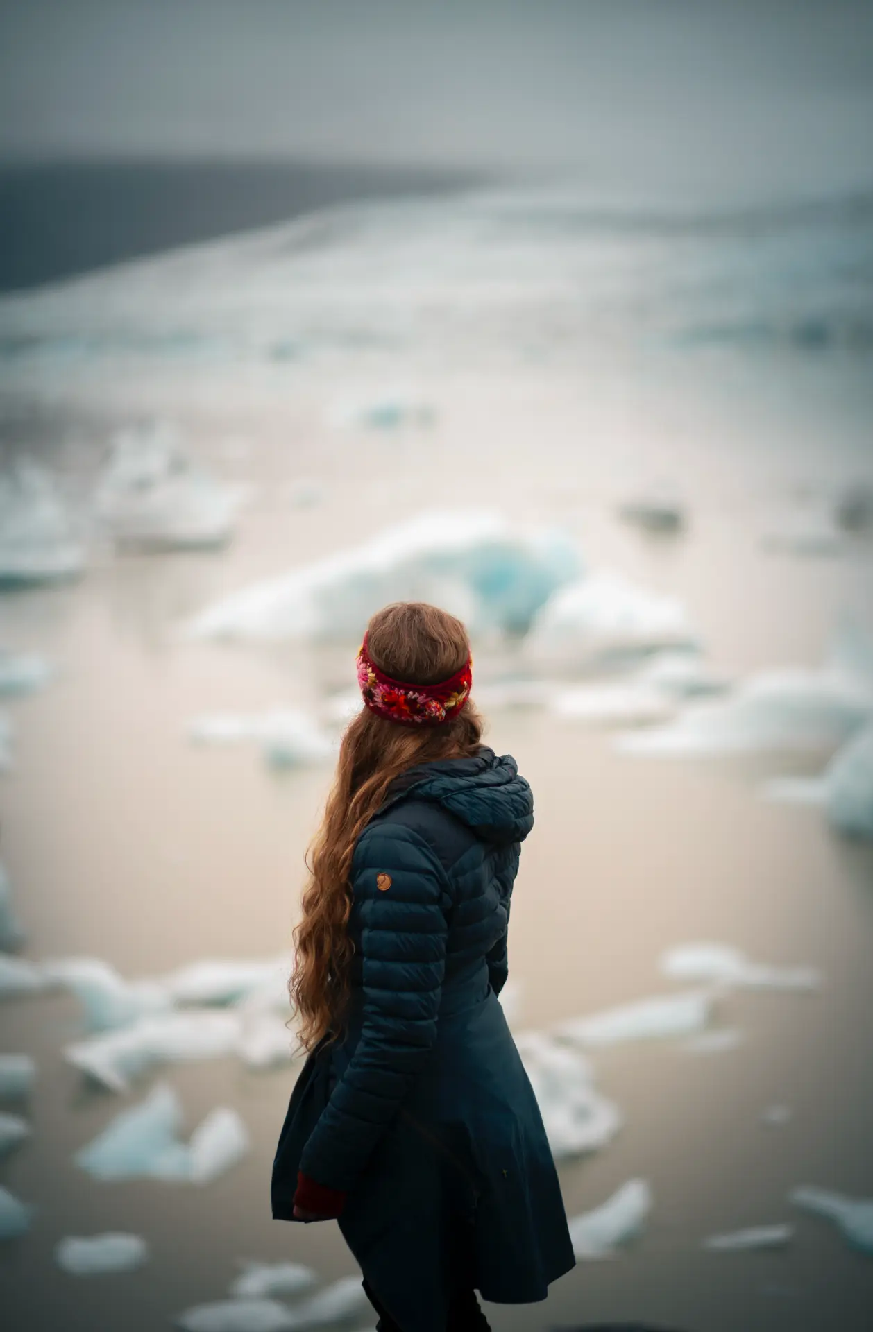 Woman looking out over ice floes in a lagoon
