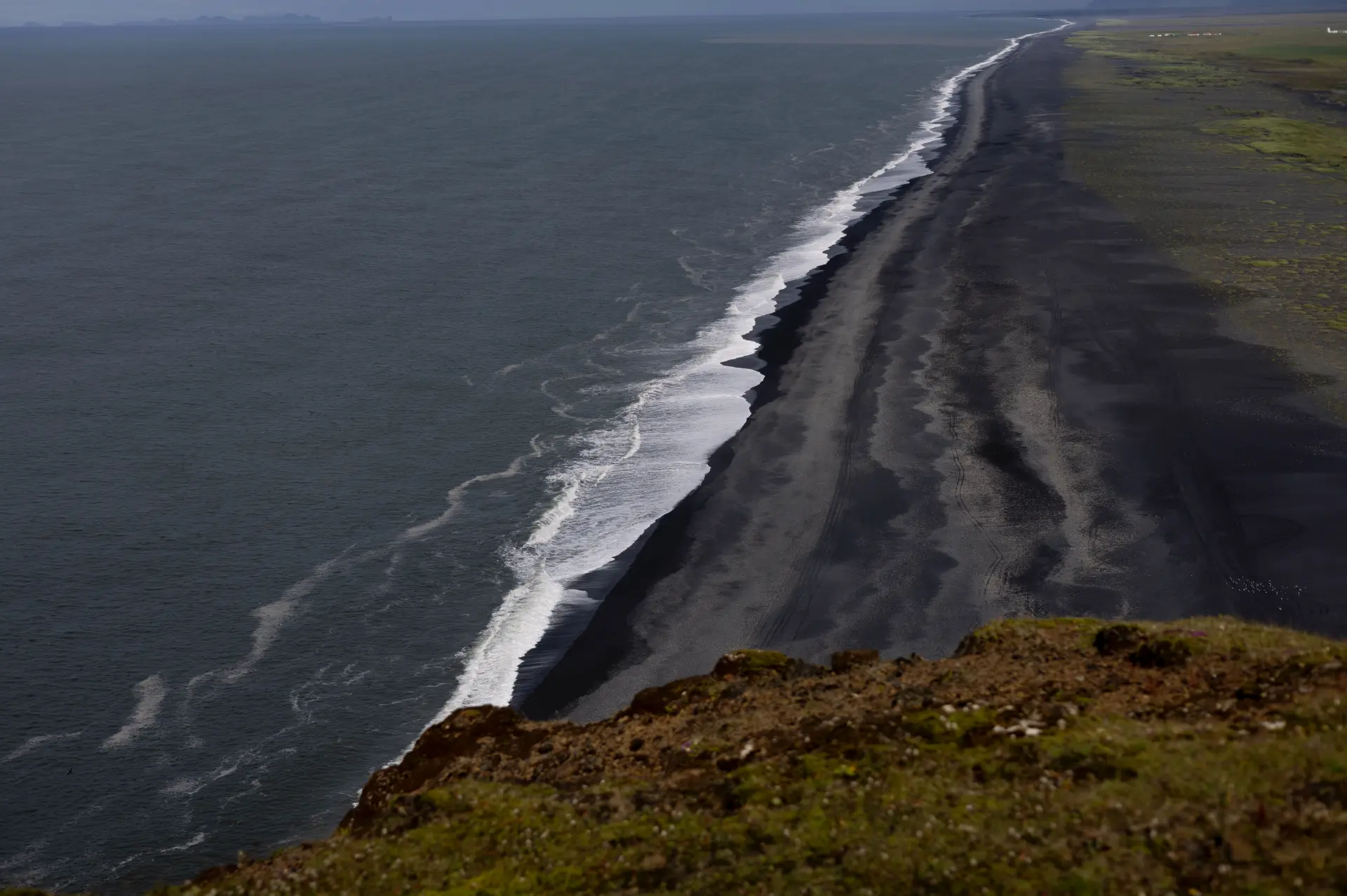 Black sand coastline seen from a clifftop