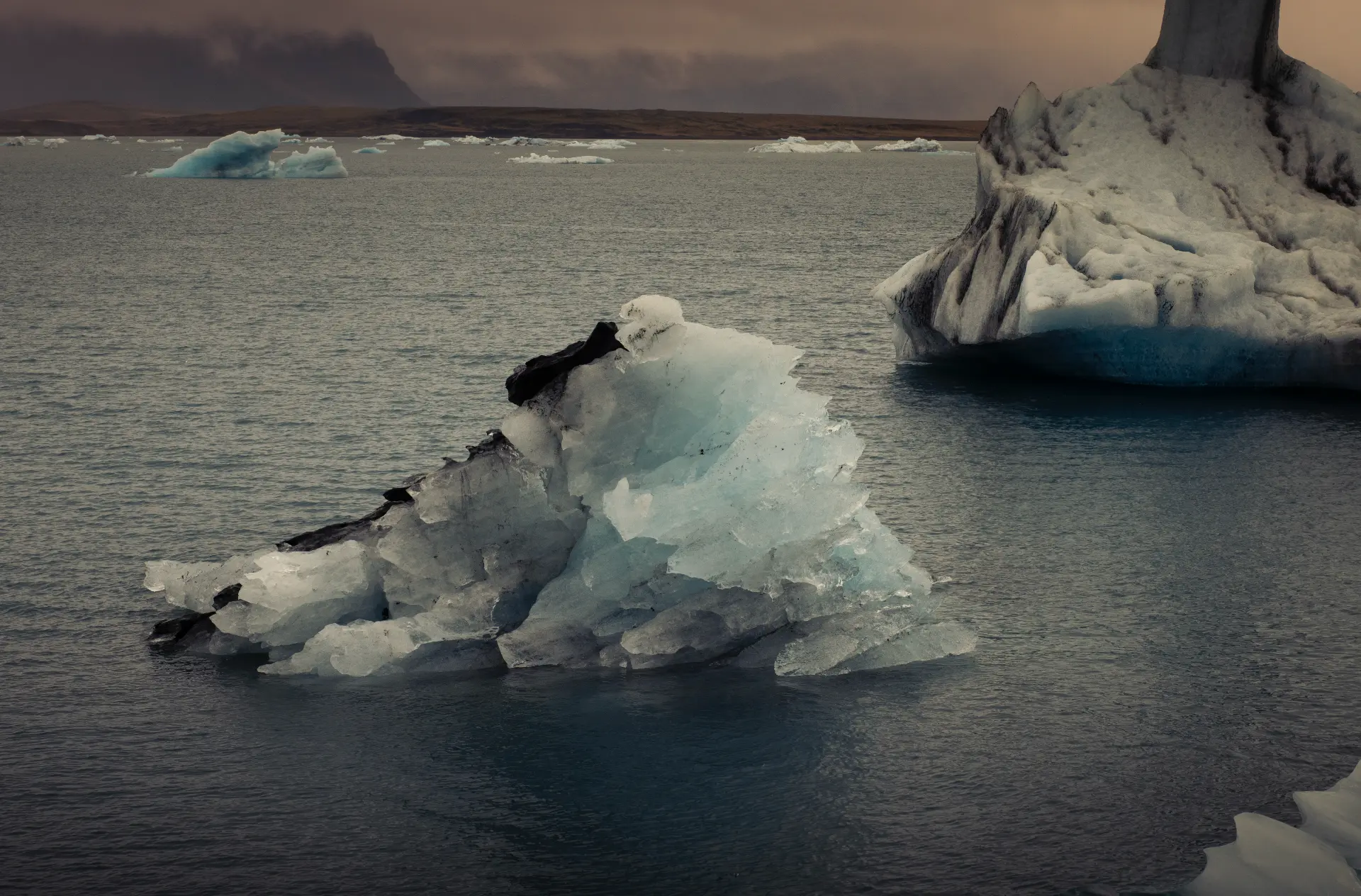 Iceberg floating in a still lagoon at dusk