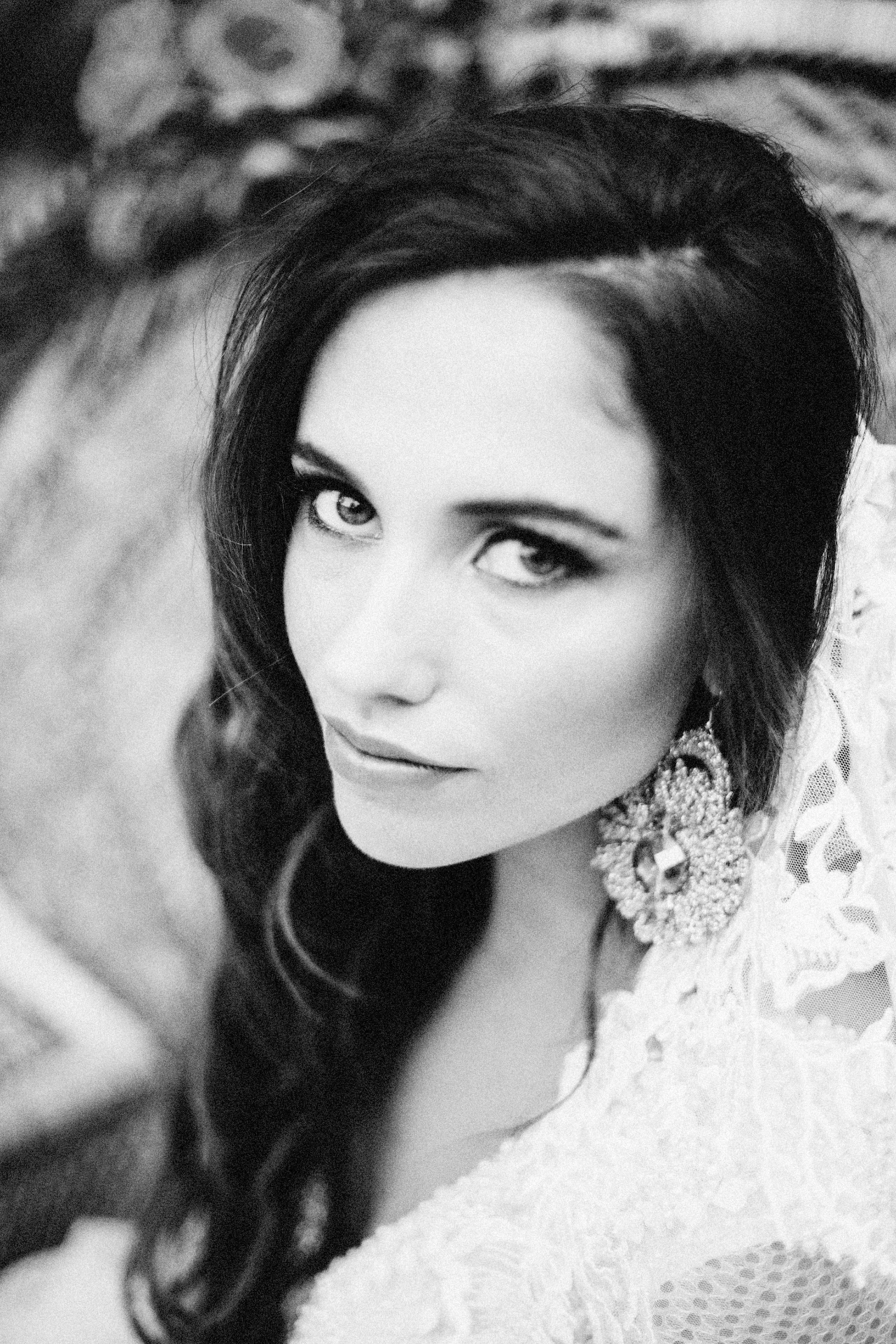 Black and white beauty portrait of a model in lace with crystal earrings