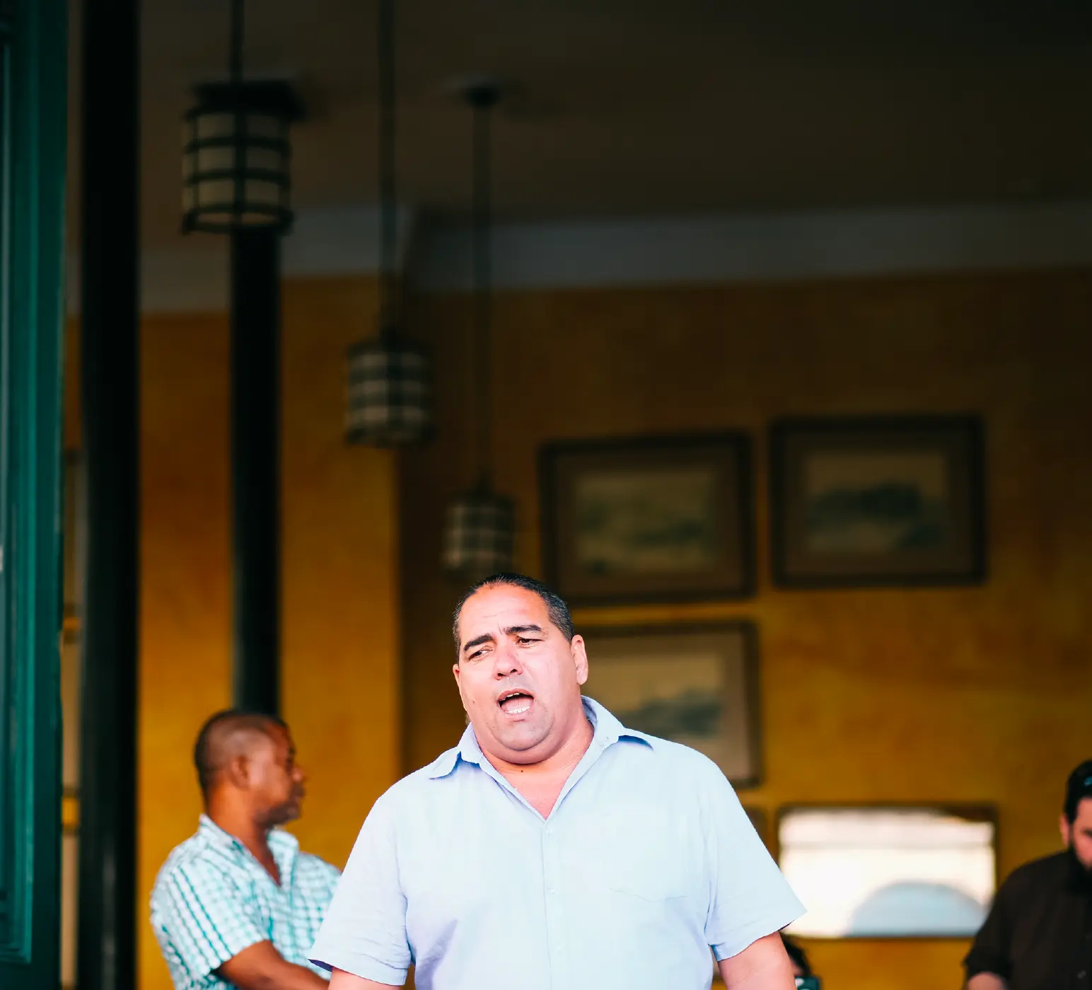 Man singing in a doorway of an ochre-walled Havana bar