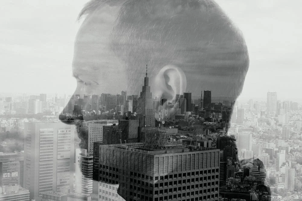 Double exposure portrait blended with a city skyline