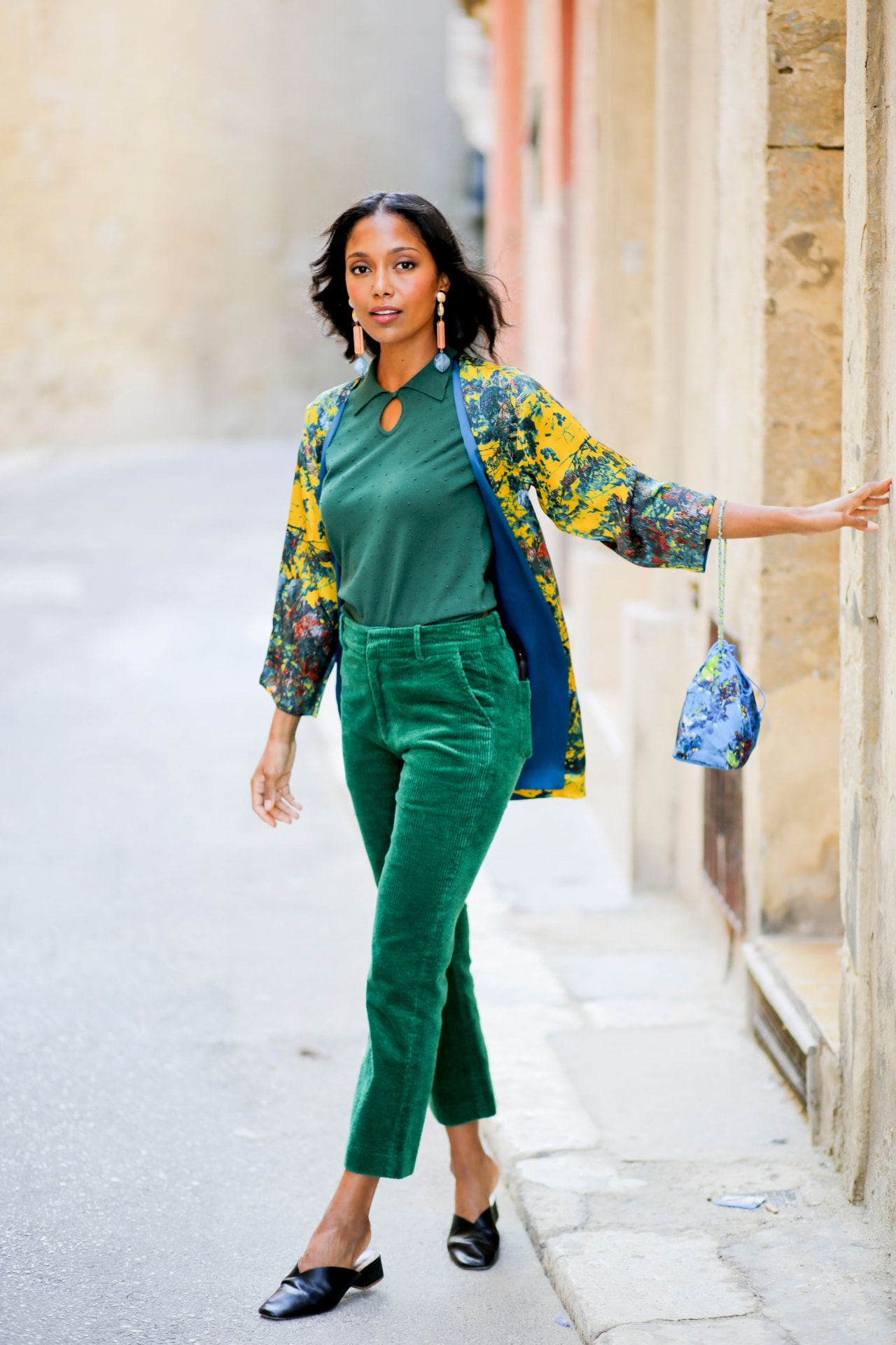 Model in green corduroy and printed jacket in a Malta street