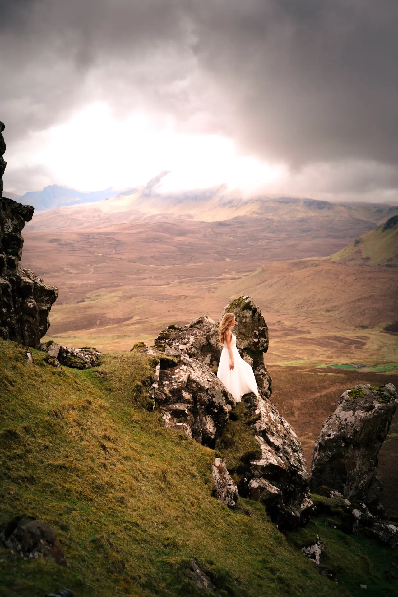 Figure in a white gown on the Quiraing as light breaks through cloud